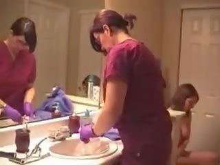 Ibu dan muda wanita memasukkan cairan ke anus